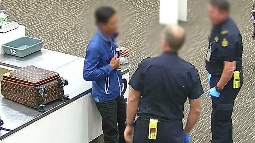 Australian Border Force officer talking to man at airport