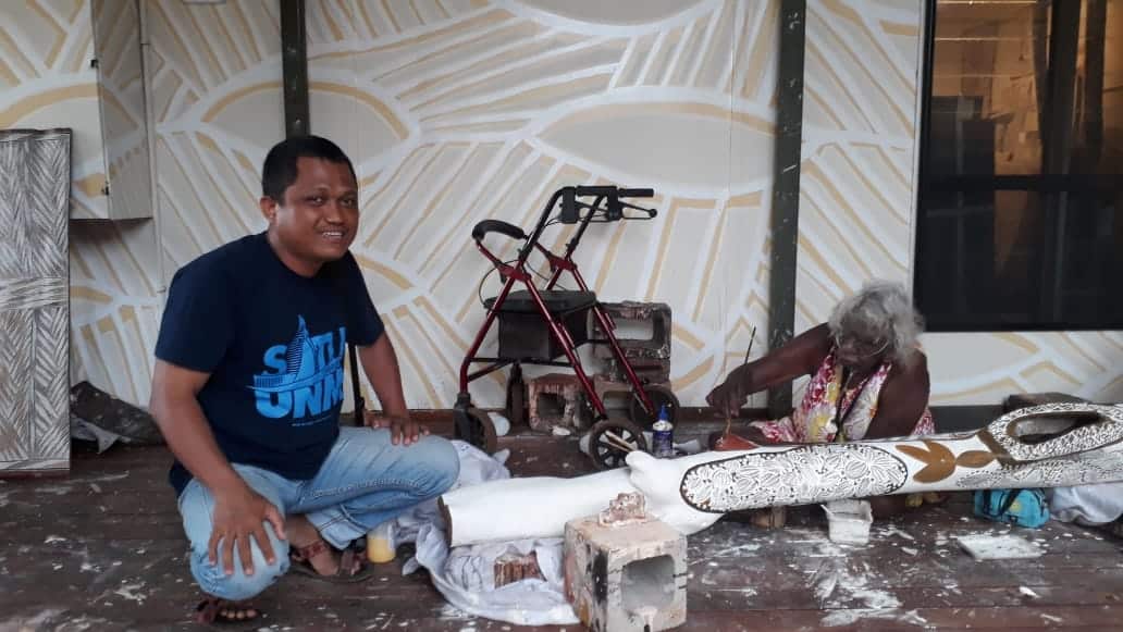 Nurabdiansyah observing a Yolnu artist at work at Yirrkala Arts Centre, during his visit to Arnhem Land, 2018. 