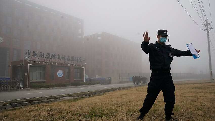 A security personnel moves journalists away from the Wuhan Institute of Virology after a World Health Organization team arrives in January, 2021. 