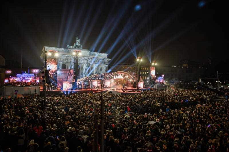 Spectators stand in front of the Brandenburg Gate during the beginning of the New Year's Eve celebrations in Berlin.