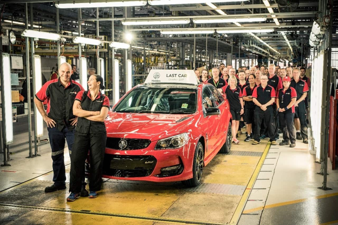 A supplied image of staff posing for a photograph with the last vehicle to roll off the production line at the Holden plant in Adelaide
