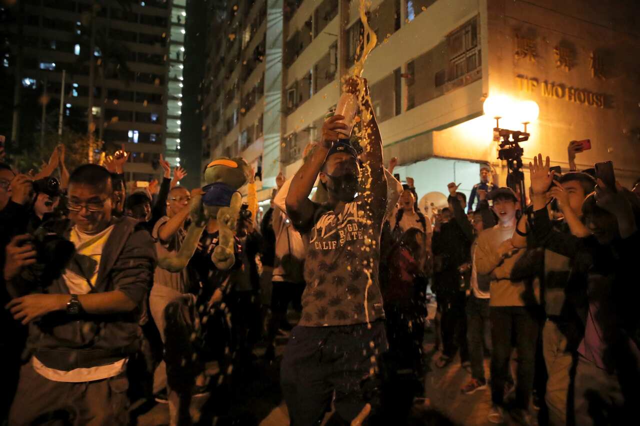 Pro-democracy supporters celebrate after pro-Beijing politician Junius Ho lost his election in Hong Kong.