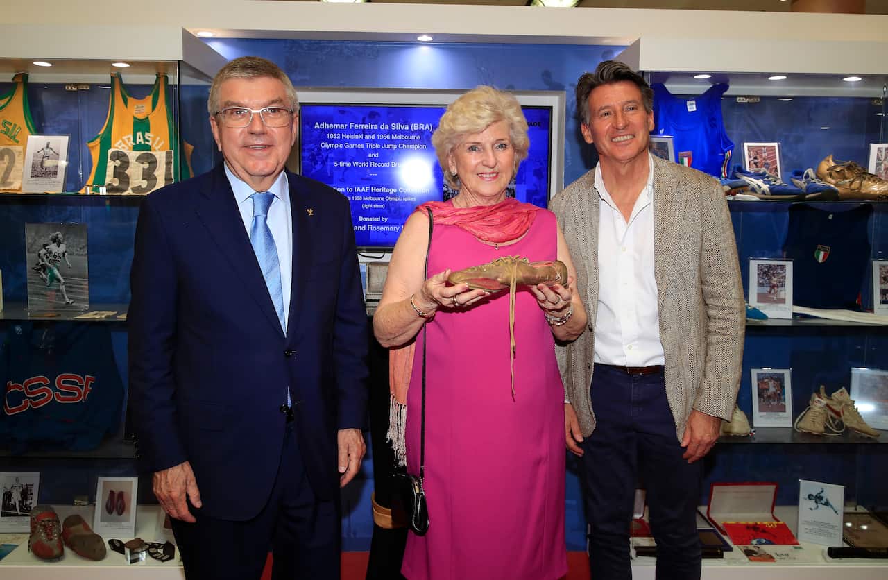 President of the International Olympic Committee, Thomas Bach (L), joins IAAF President, Lord Sebastian Coe (R), as he is presented a donation by Rosemary Mula.