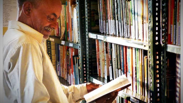 Older man Reading Book In Library
