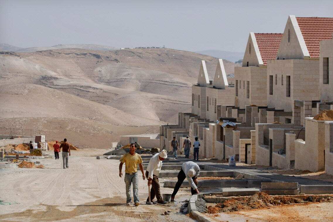 FILE: Palestinian men work at a construction site in the West Bank Jewish settlement. 