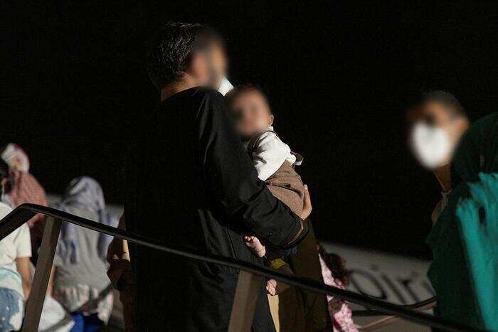 پناهندگان افغان در حال سوار شدن بر هواپیمای کوانتس در پایگاه نظامی اصلی آسترالیا در خاور میانه.