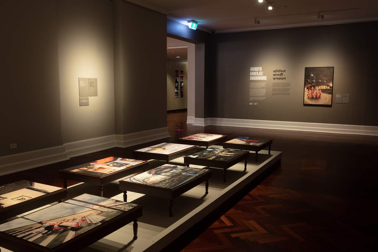 Each photograph is printed on the top of a pidi, a low wooden table traditionally used in the home for domestic and devotional purposes.