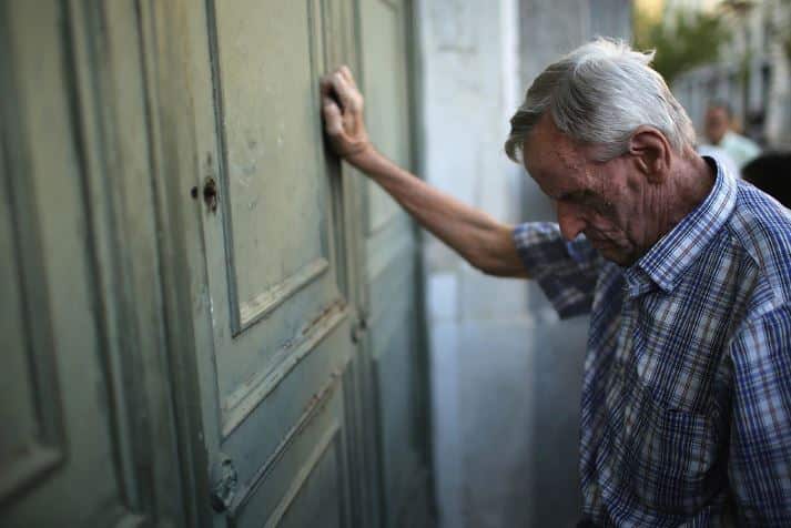 Anciano descansa junto a una puerta.