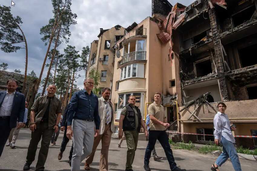 Australian Prime Minister Anthony Albanese, third left, looks at apartment buildings damaged by Russian shelling, during his visit to Irpin, on the outskirts of Kyiv, Ukraine, Sunday, 3 July, 2022.