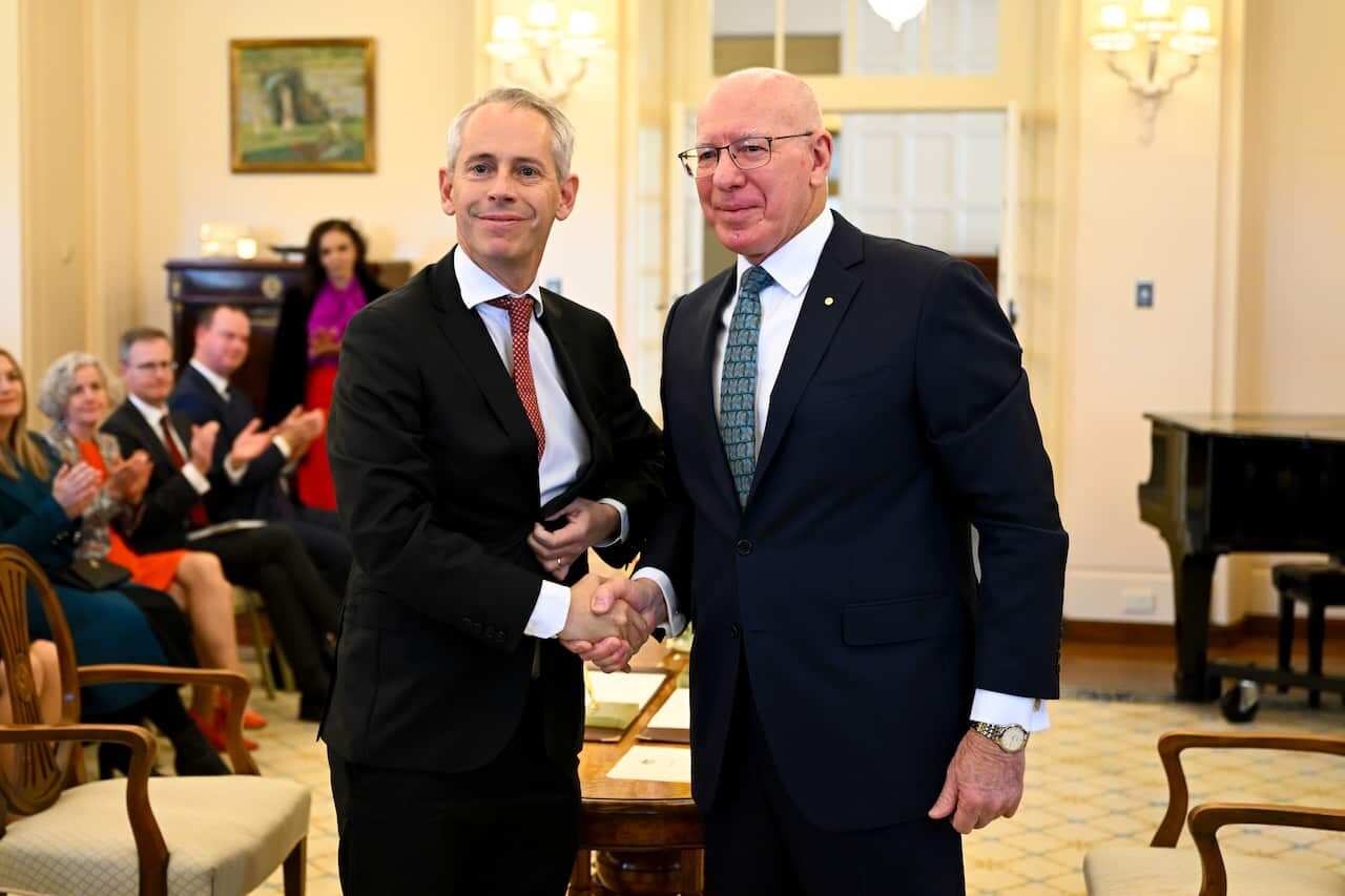 Minister for Immigration Andrew Giles (left) shakes hands with Australian Governor-General David Hurley during a swearing-in ceremony at Government House in Canberra. 