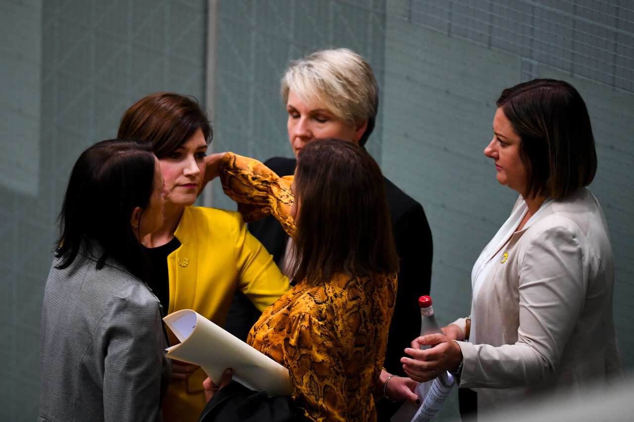 Liberal MPs Nicolle Flint and Celia Hammond embrace with Labor MPs Anne Aly, Tanya Plibersek and Kristy McBain ahead of House of Representatives Question Time at Parliament House in Canberra, Thursday, March 18, 2021. (AAP Image/Lukas Coch) NO ARCHIVING