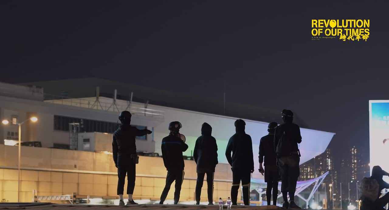 Protester standing on the rooftop of the footbridge at Poly University Hong Kong