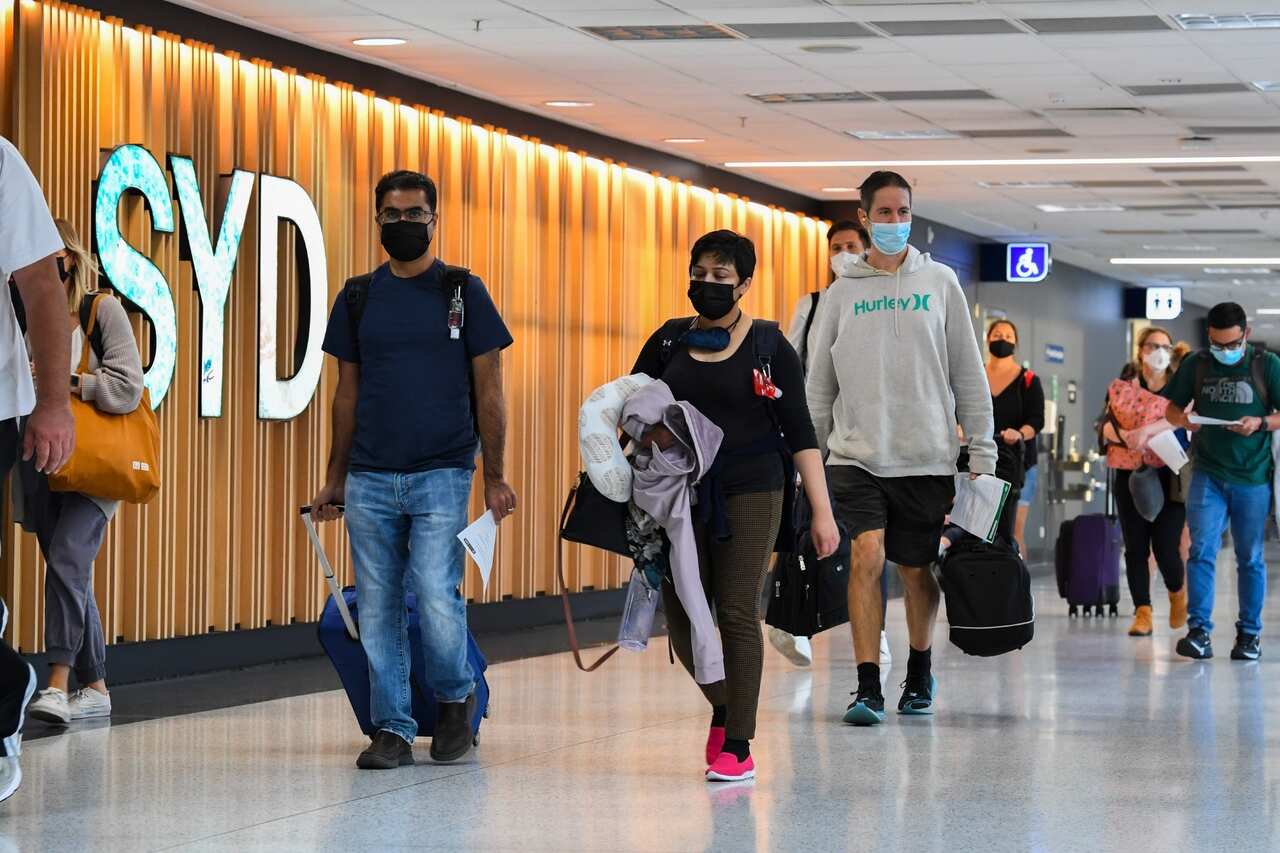 Passengers arrive from their overseas flights and walk to the arrivals hall after landing at Sydney Airport