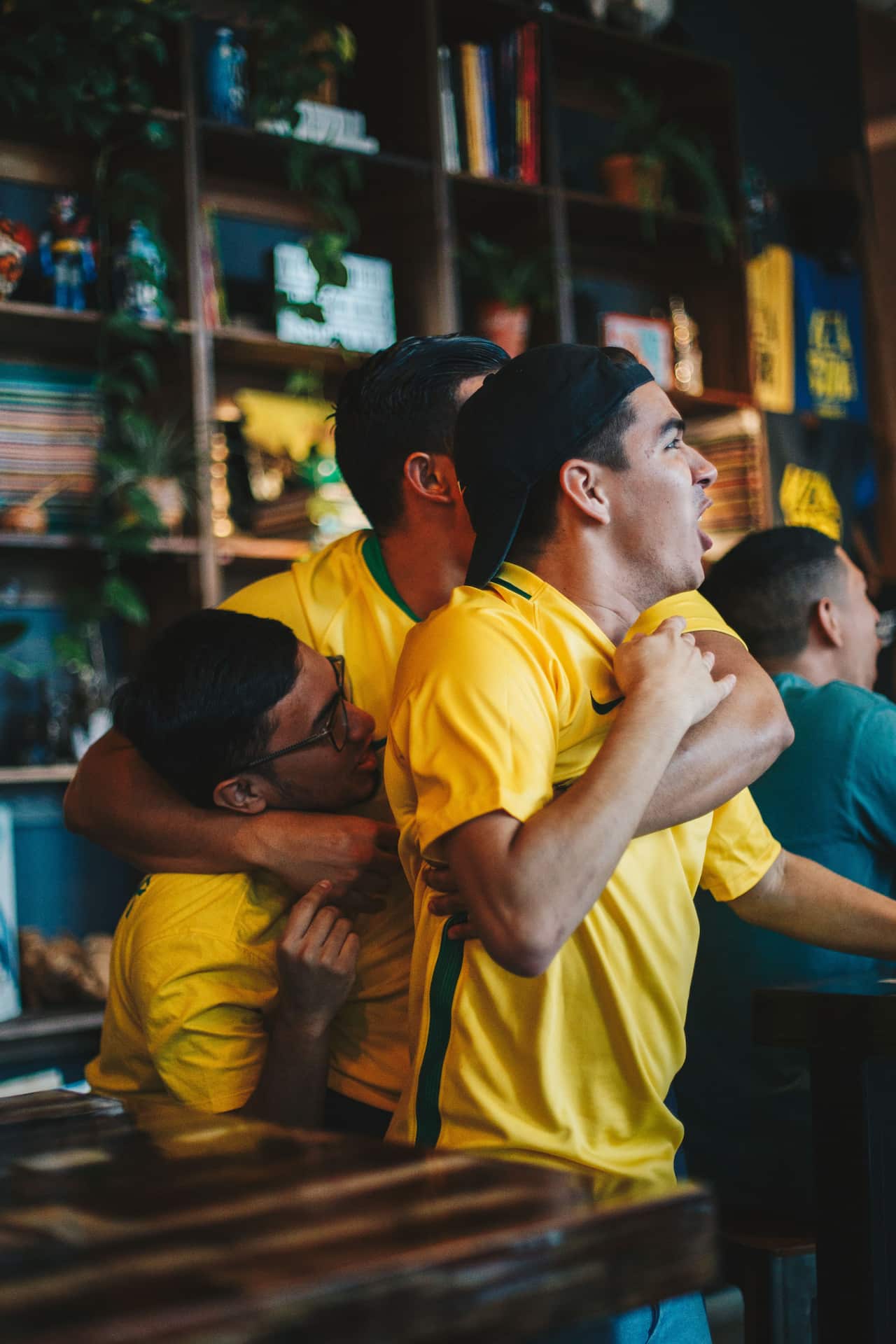 Three men wearing Australian National Team shirts cheering