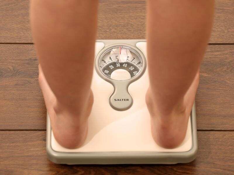 File photo of a model's legs on a weighing scale.