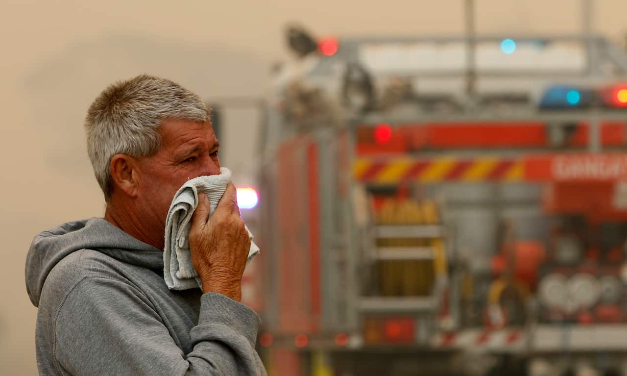 A resident watches the progress of bushfires near houses in Old Bar, NSW, Saturday 0 November, 2019. 