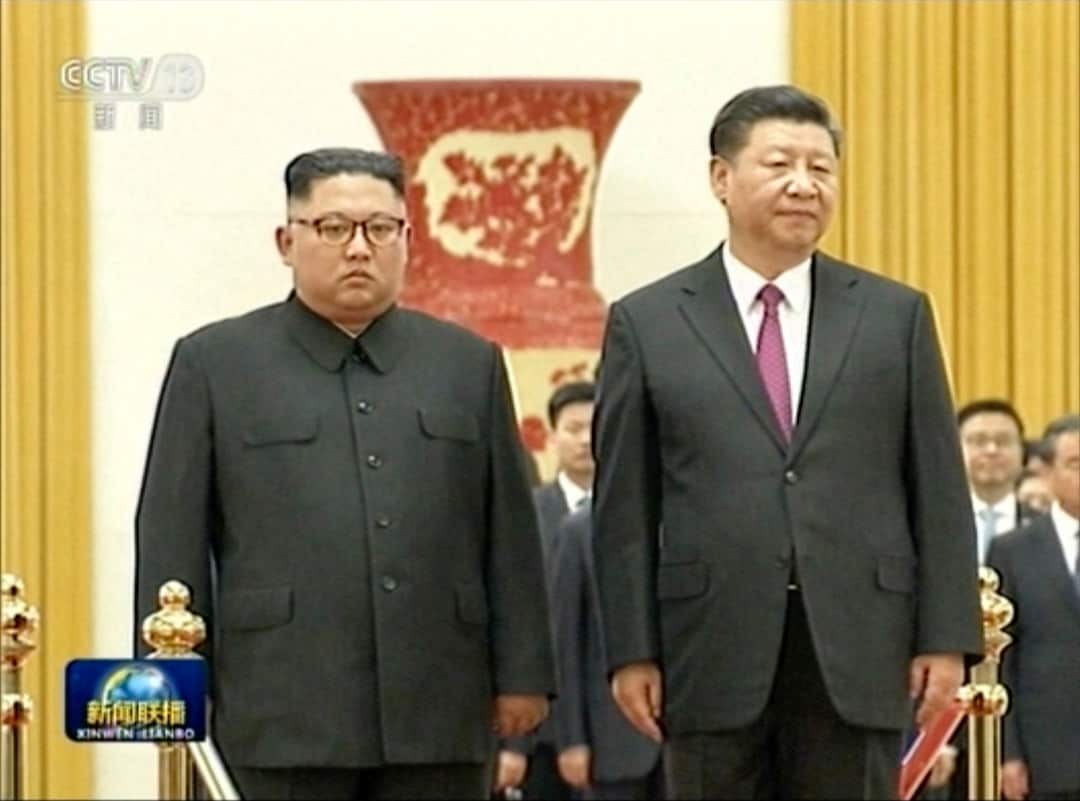 Chinese President Xi Jinping stands next to North Korean leader Kim Jong-un on Tuesday.