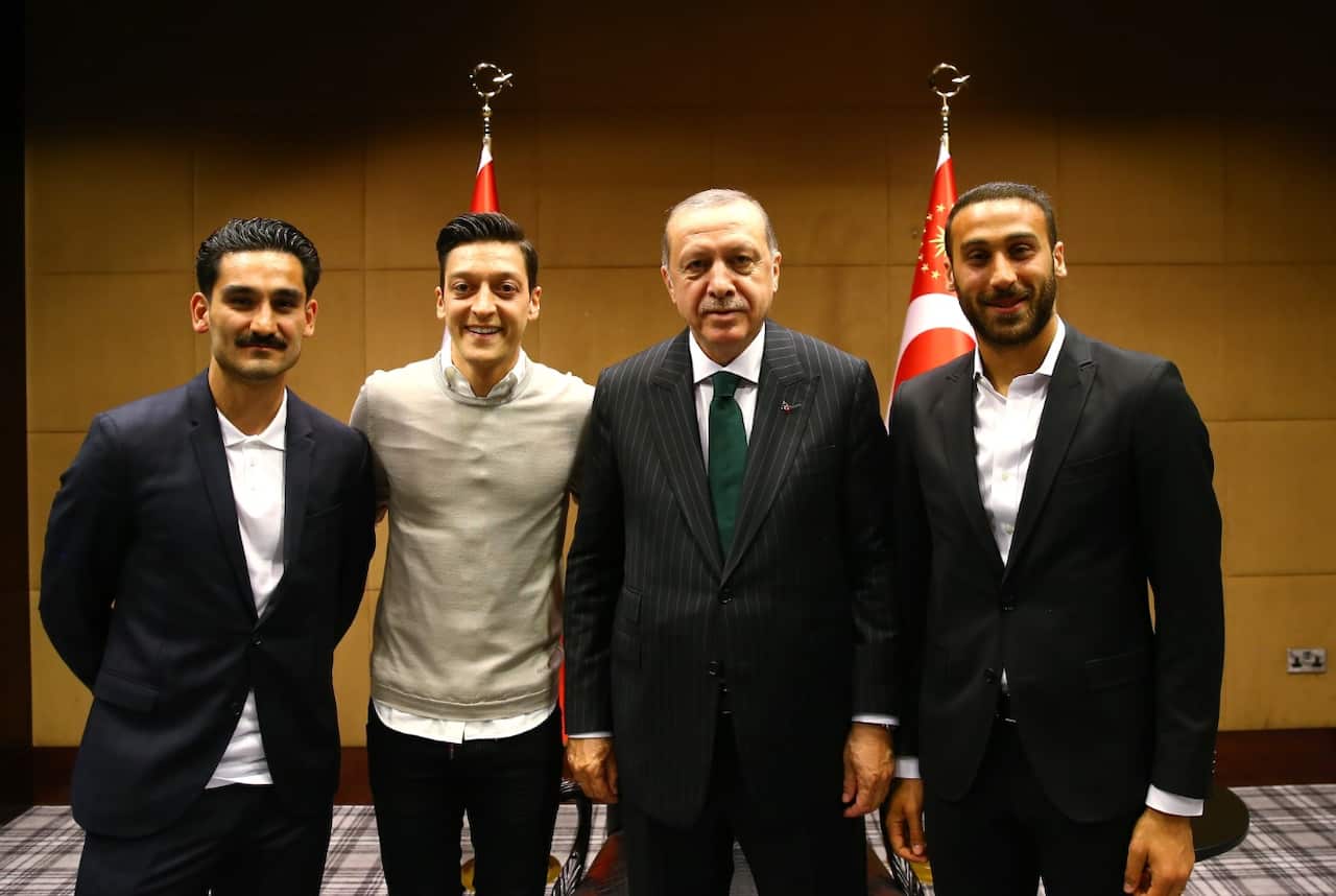 Football players Ilkay Gundogan (L), Mesut Ozil (L-2) and Cenk Tosun (R) pose for a photo with Turkish President Recep Tayyip Erdogan (R-2) in London
