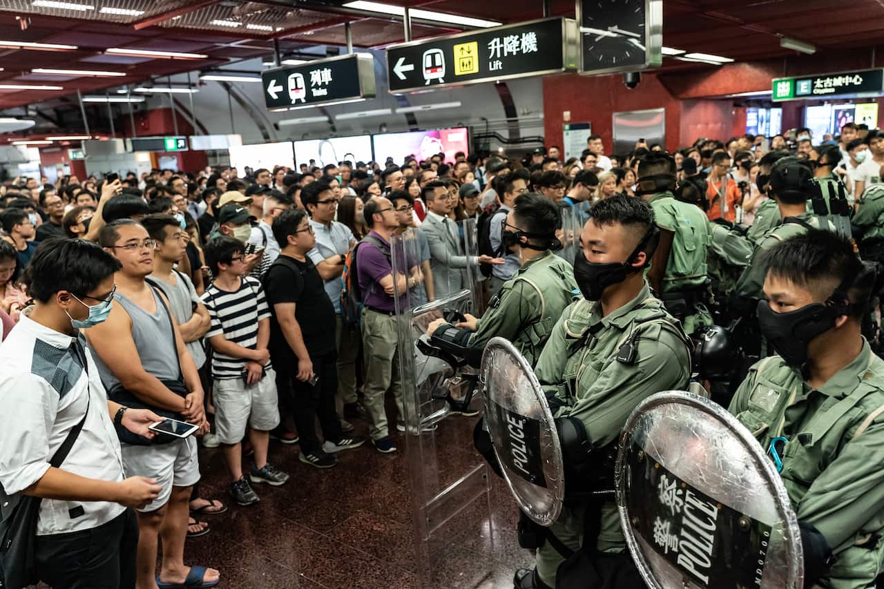 Pro-democracy supporters and local residents stand off with police at the Tai Koo MTR station.