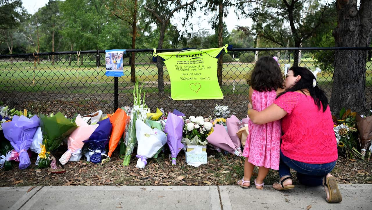 Members of the community gather at the memorial for the four children killed in a car crash in Sydney.