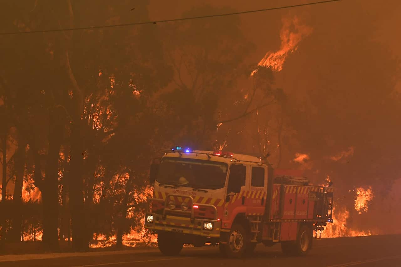 Rural Fire Service (RFS) crews battle the bushfires near homes along the Old Hume Highway near the town of Tahmoor.