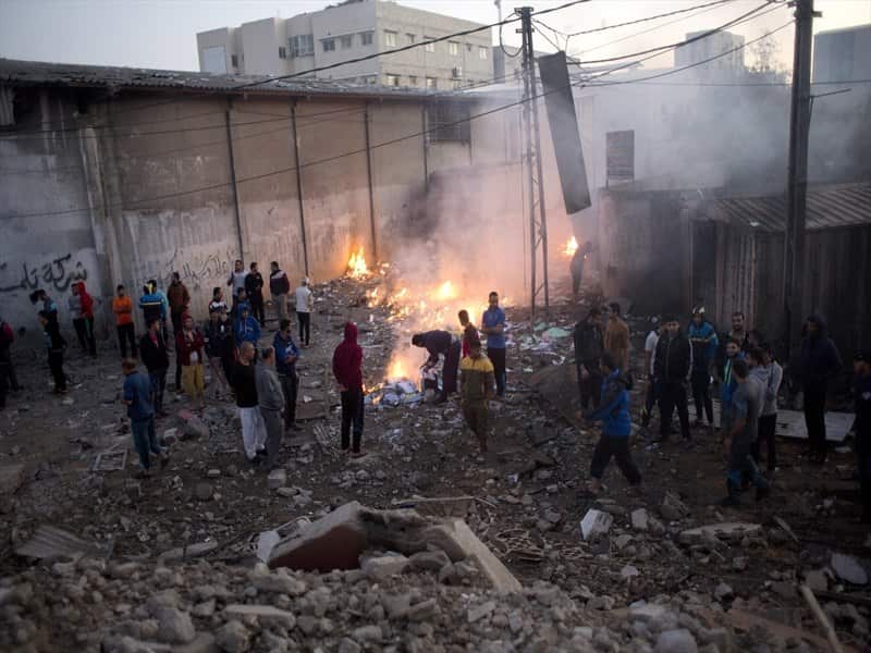 Palestinians in the rubble of destroyed buildings