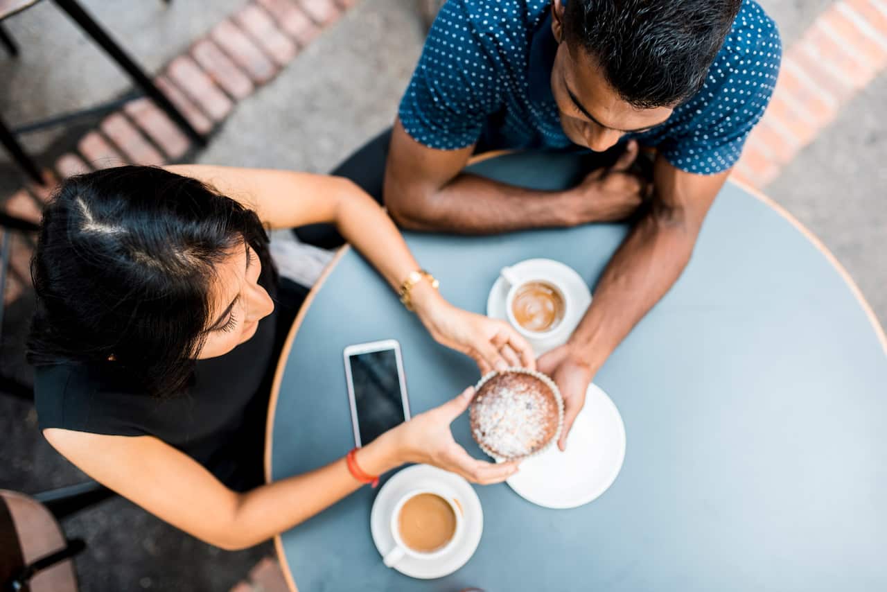 Couple drinking coffee and eating dessert at a cafe