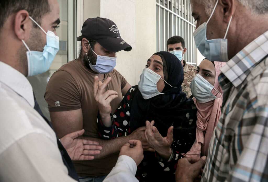 A mother of a severely burned son weeps outside a local hospital after the fuel tank explosion.