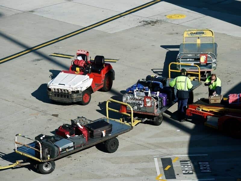 Baggage handlers unload luggage from a QANTAS plane