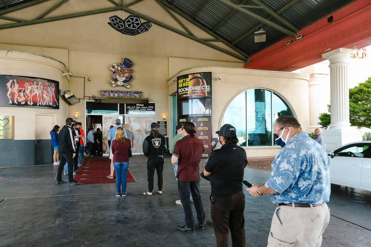 people wait in line during a pop-up COVID-19 vaccine event at Larry Flynt's Hustler Club in Las Vegas. It's one of several methods health officials are employing here and across the country to bring vaccines directly to people to counter waning demand. 