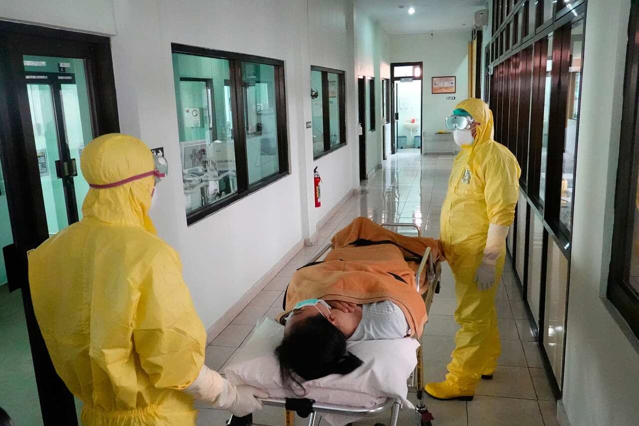  Health workers in protective suits take part in a drill in handling coronavirus cases at a hospital in Denpasar, Bali.