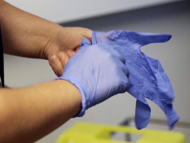 A man wearing latex gloves