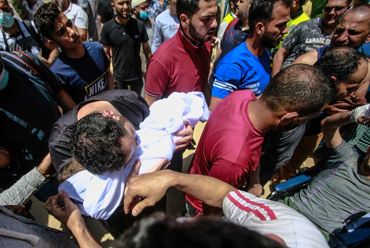 Palestinians carry the body of a Palestinian child who was killed in an Israeli airstrike.