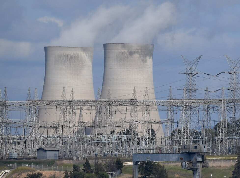 A general view of the Bayswater coal-fired power station cooling towers and electricity distribution wires in Muswellbrook
