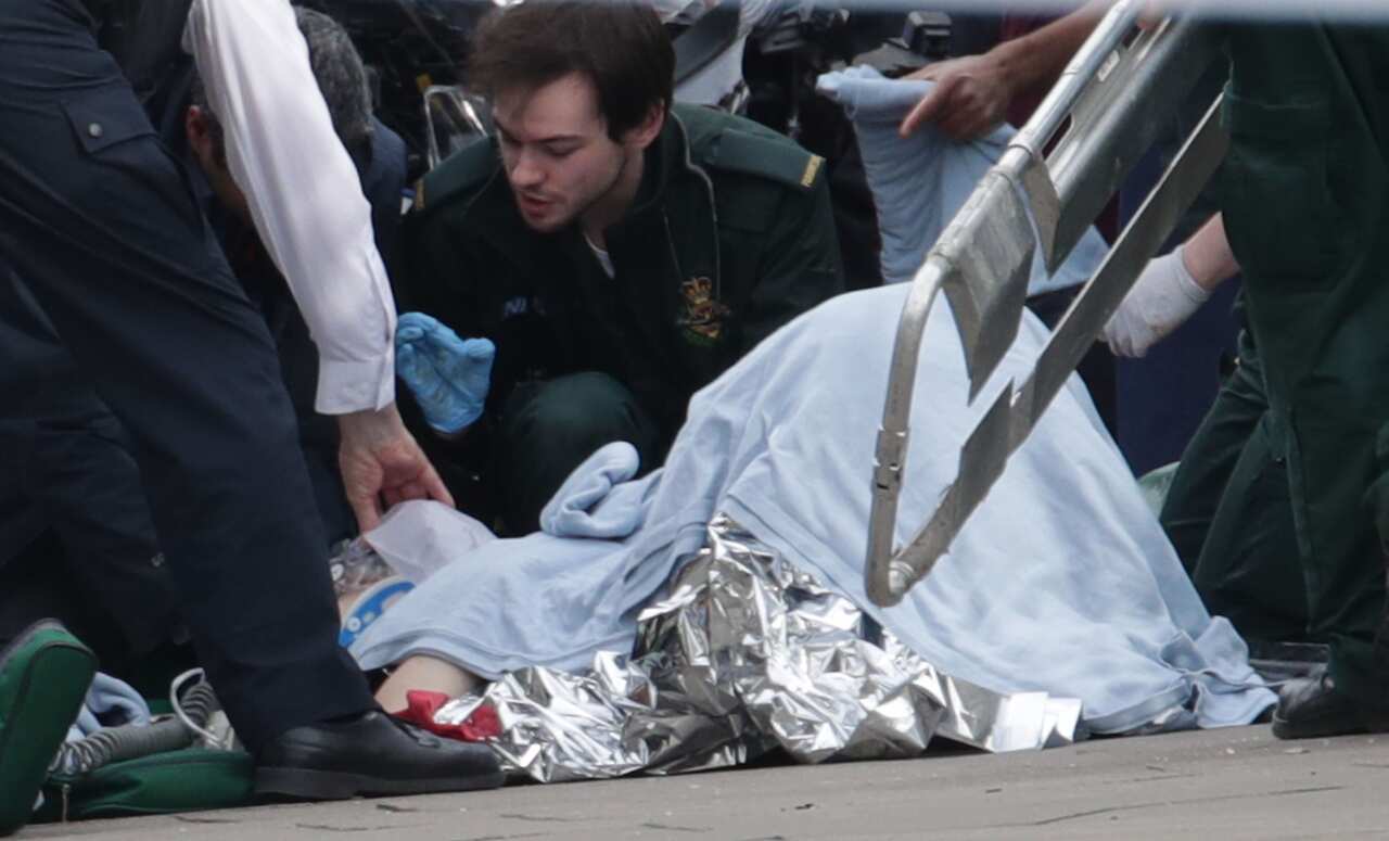 Emergency personnel attend to a victim close to the Palace of Westminster, London.