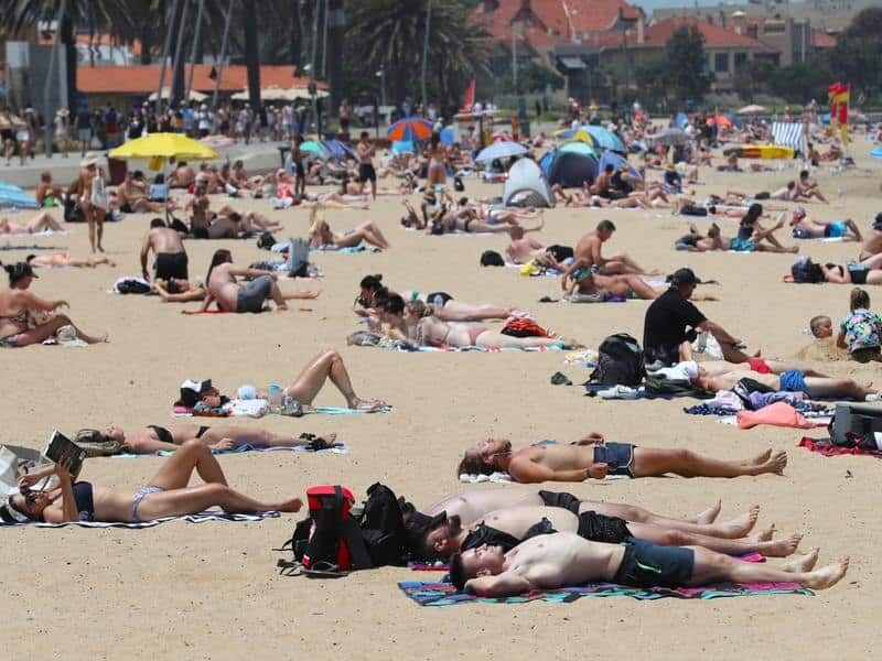 Beachgoers are seen during a hot day at St Kilda beach (file image)