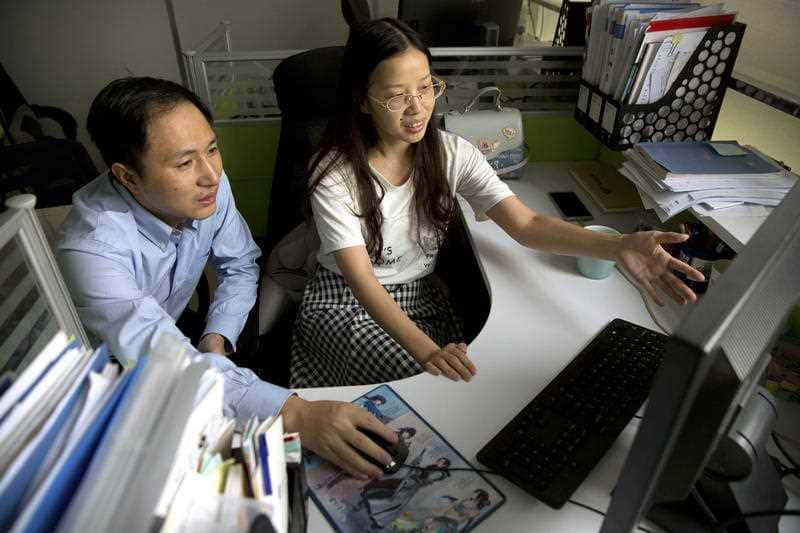 He Jiankui, left, and Zhou Xiaoqin work a computer at a laboratory in Shenzhen in southern China's Guangdong province