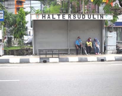 Several people with a disability wait at a bus stop in Banjarmasin.