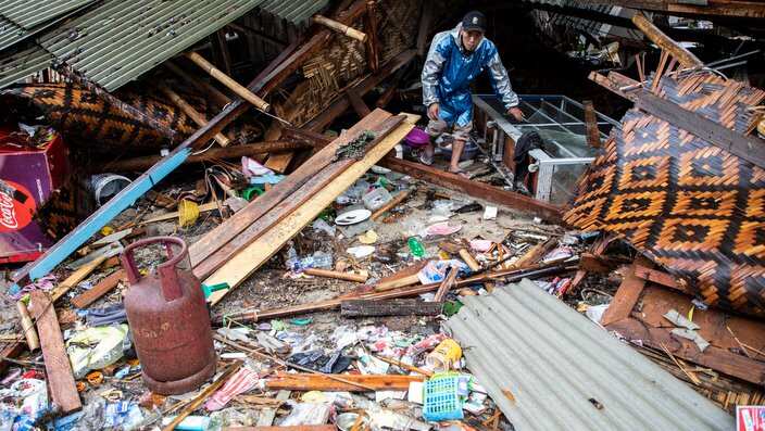 A man walks near a damaged building in Banten, on December 23, 2018, after the area was hit by a tsunami.