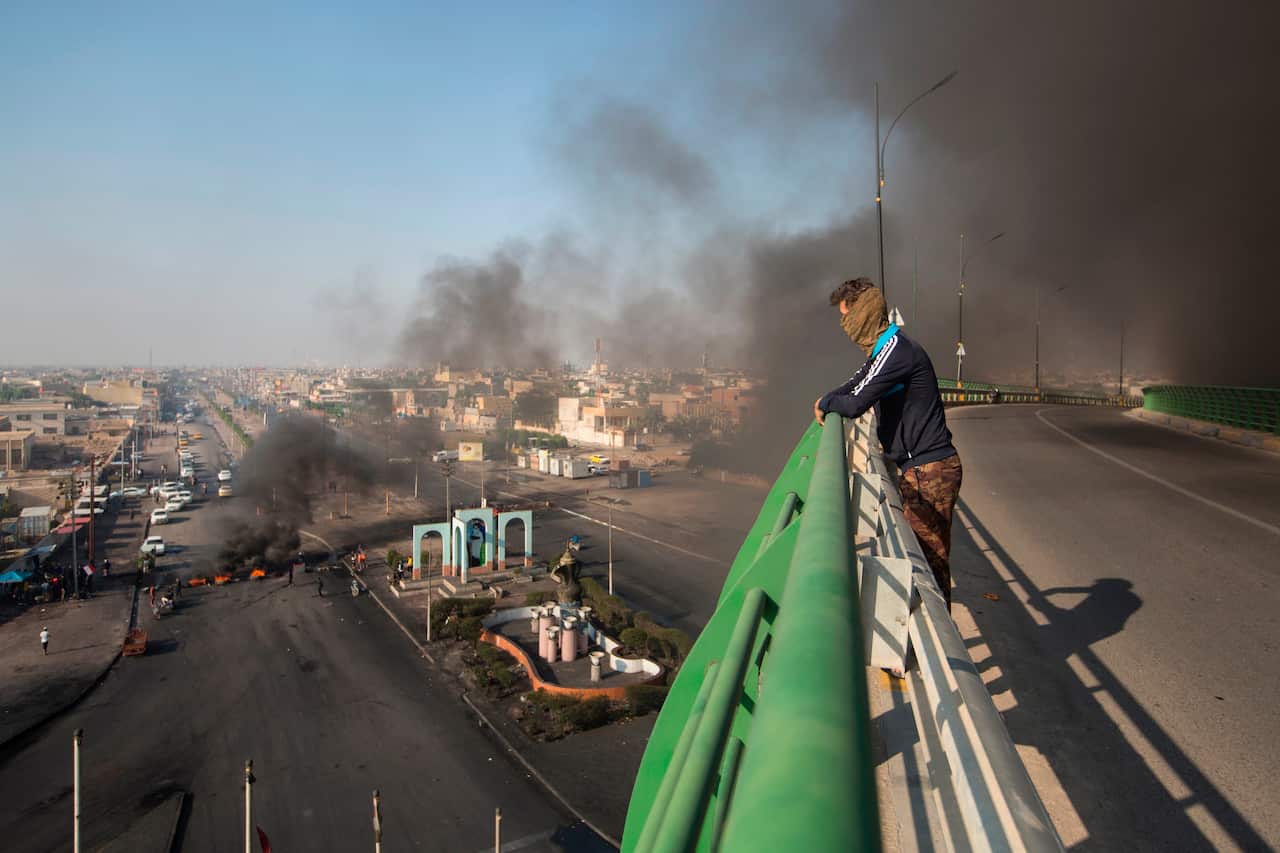 Anti-government protesters set fires to close down streets during ongoing protests in Basra, Iraq, Wednesday, Nov. 27, 2019. (AP Photo/Jamil al-Jurani)