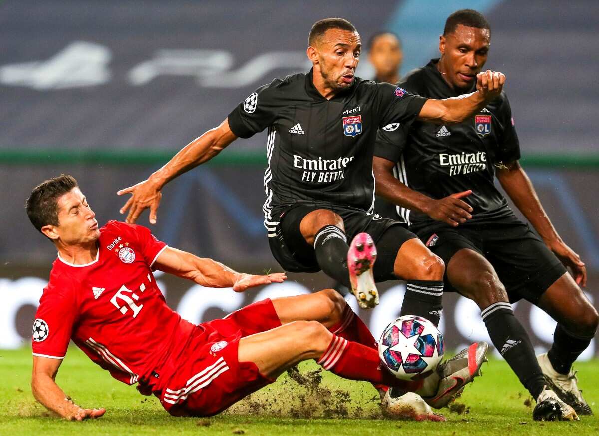 Lyon's Fernando Marcal (C) in action against Bayern Munich's Robert Lewandowski (L) during the UEFA Champions League semi final match held at Jose Alvalade Stadium in Lisbon, Portugal, 19 August 2020. 