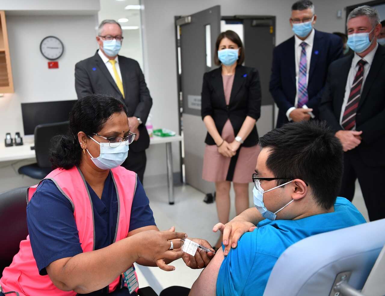 NSW Premier Gladys Berejiklian watches a radiographer get his first COVID vaccination