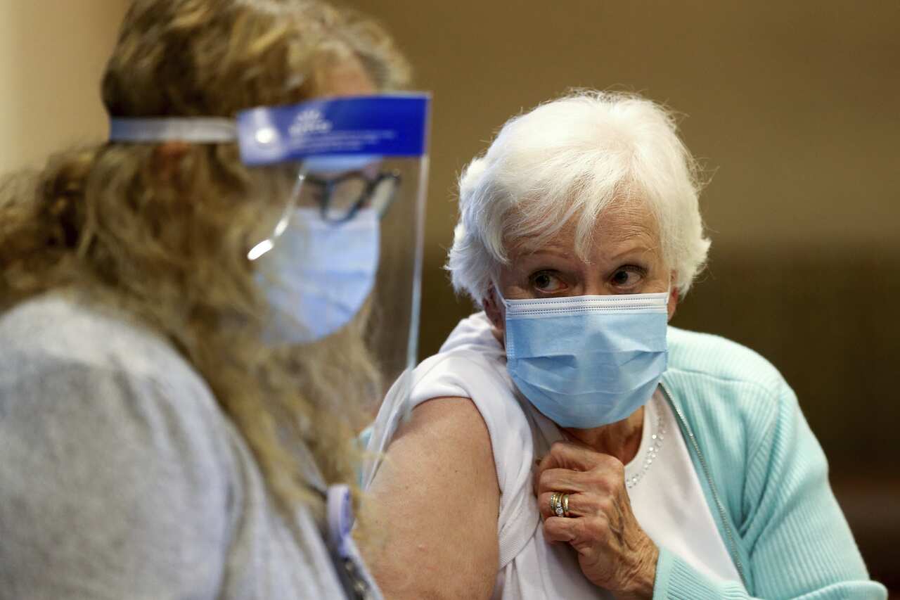 A woman receives her first dose of the COVID-19 vaccine.