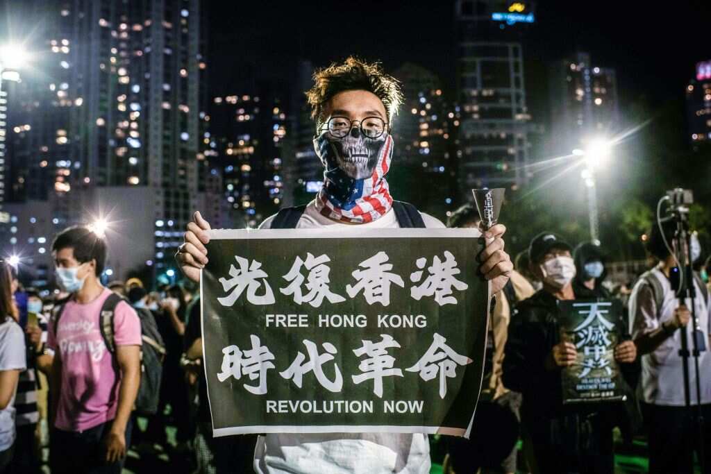 A pro-democracy protester holds a banner with pro-