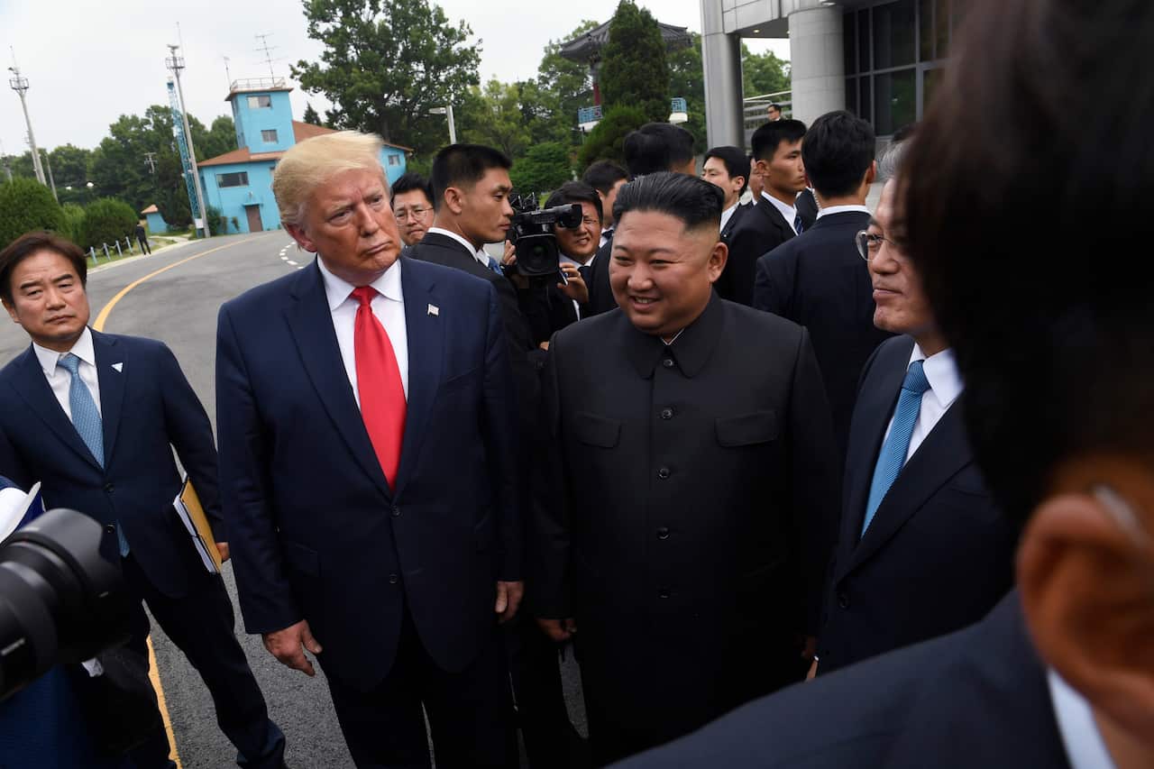 President Donald Trump, left, North Korean leader Kim Jong Un, center