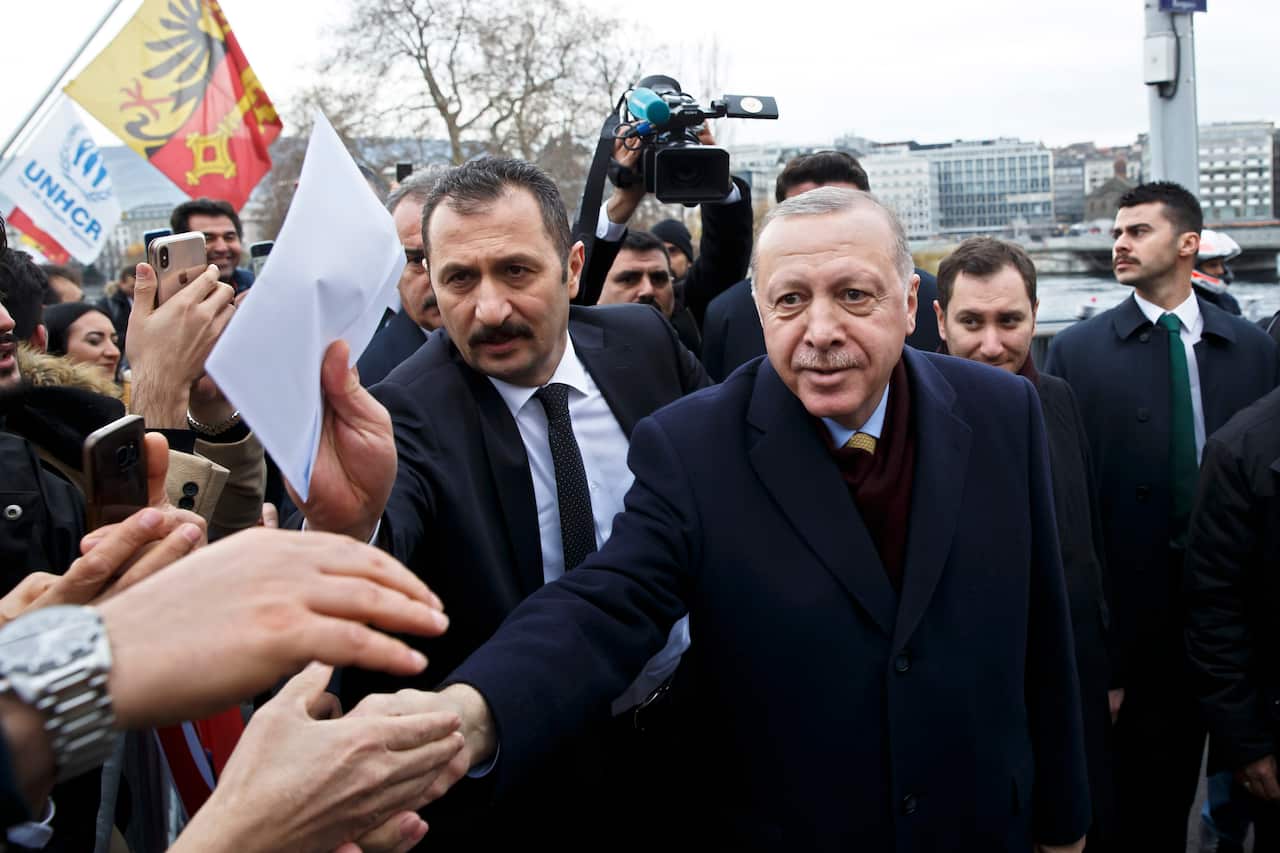 Turkey's President Recep Tayyip Erdogan greats people when arriving at his hotel one day before the opening UNHCR - Global Refugee Forum in Geneva, Switzerland, Monday, Dec. 16, 2019. (Salvatore Di Nolfi/Keystone via AP)