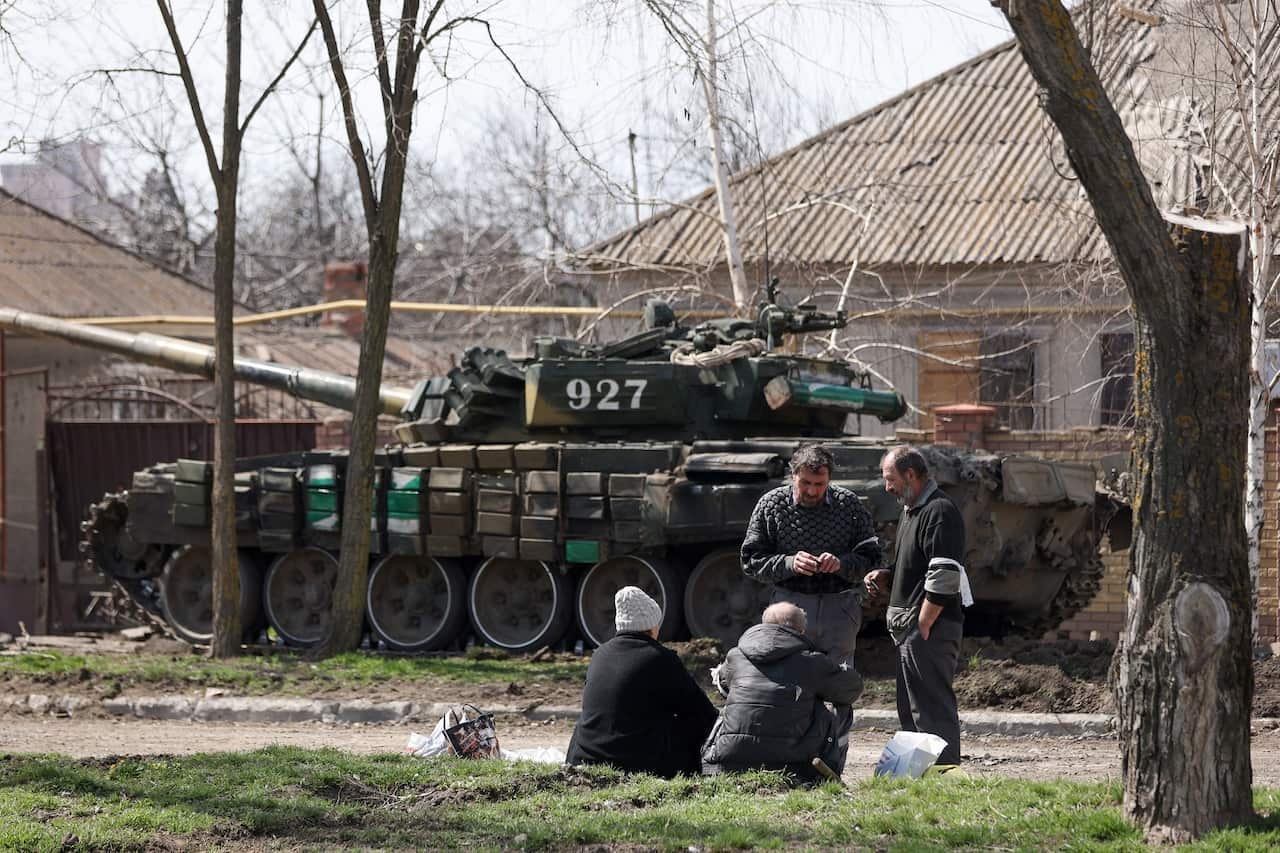 Local residents and a tank on a street in the city of Mariupol 
