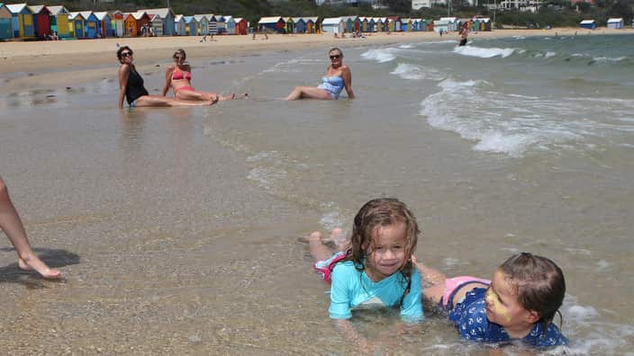 People enjoy the hot conditions on Brighton Beach in Melbourne. 