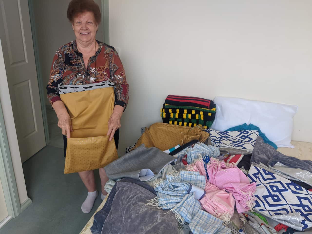 Greek Australian granny sewing pouches for injured animals
