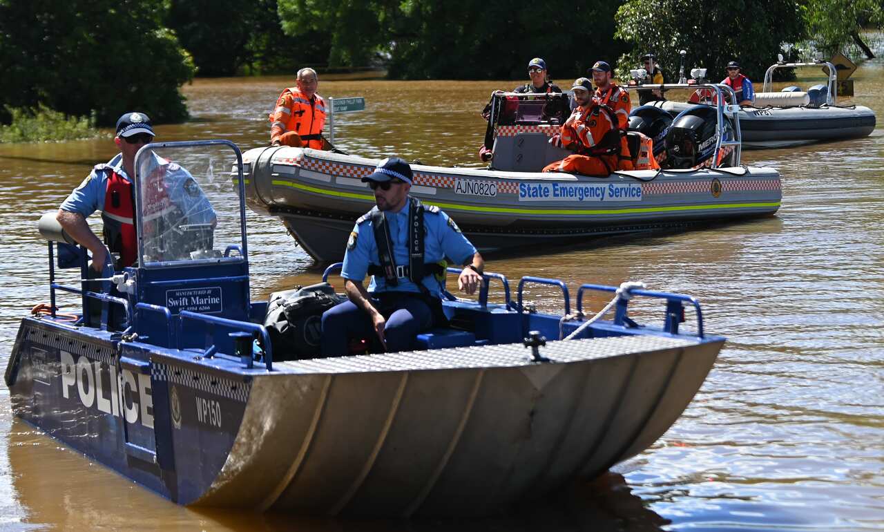 NSW State Emergency Service workers and police are seen in boats amid flooding in the suburb of Windsor, north west of Sydney on Wednesday.